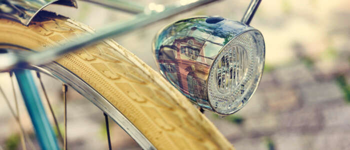 Nahaufnahme eines Fahrradlichts, in dem sich ein Wahrzeichen der Stadt Emmendingen spiegelt.