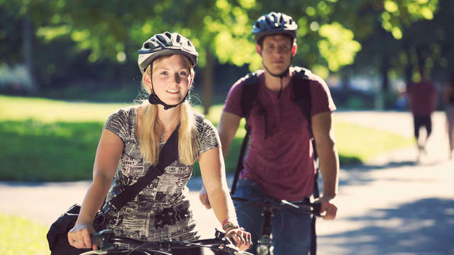 Fahrradfahrerin und ihr Begleiter sind in der Stadt unterwegs