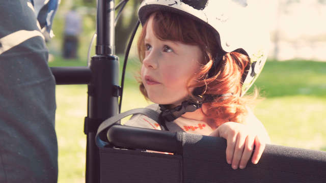 Ein Kind fährt im Lastenrad mit